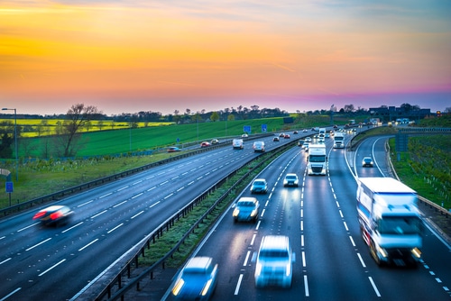 Voitures roulant sur une autoroute à la tombée du jour