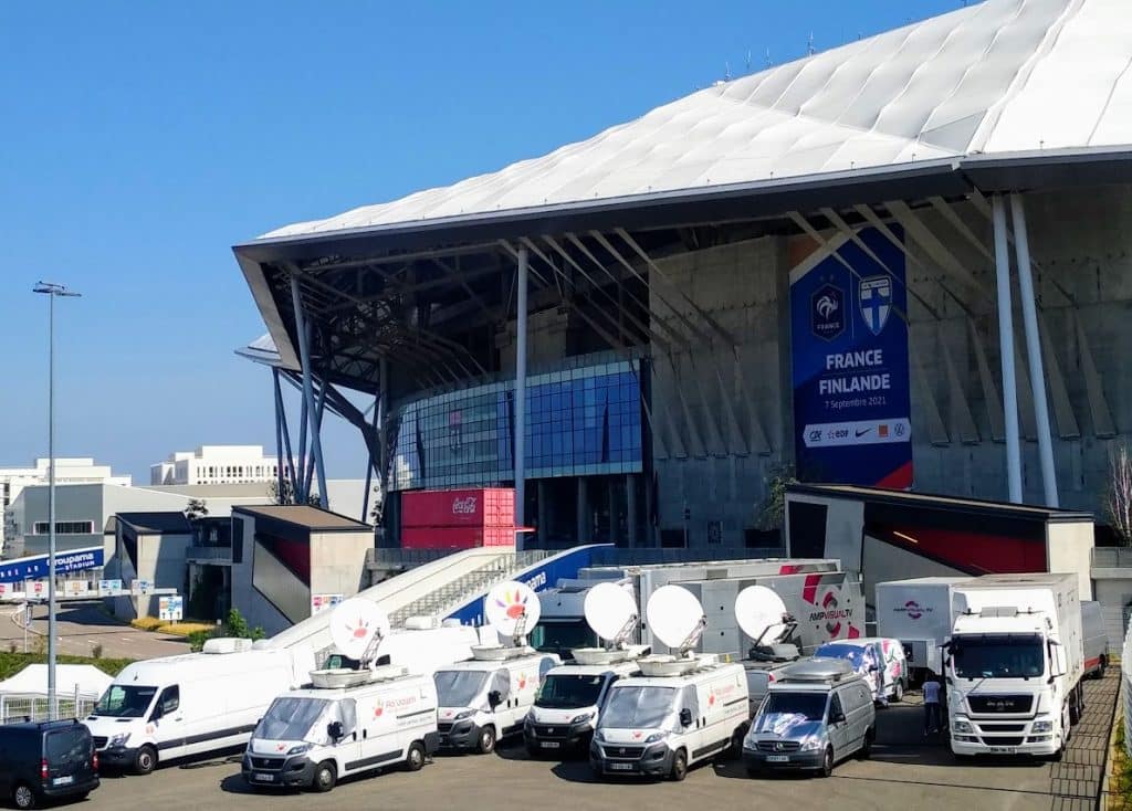 Plusieurs camions Ad Valem devant un stade pour le match de rugby France Irlande