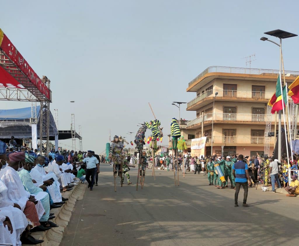 Personnes qui dansent dans une rue du Bénin en costume