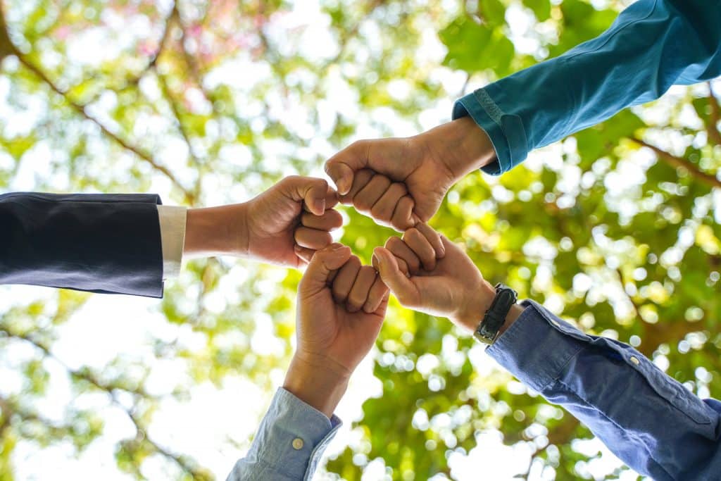quatre poings serrés joints sous un arbre